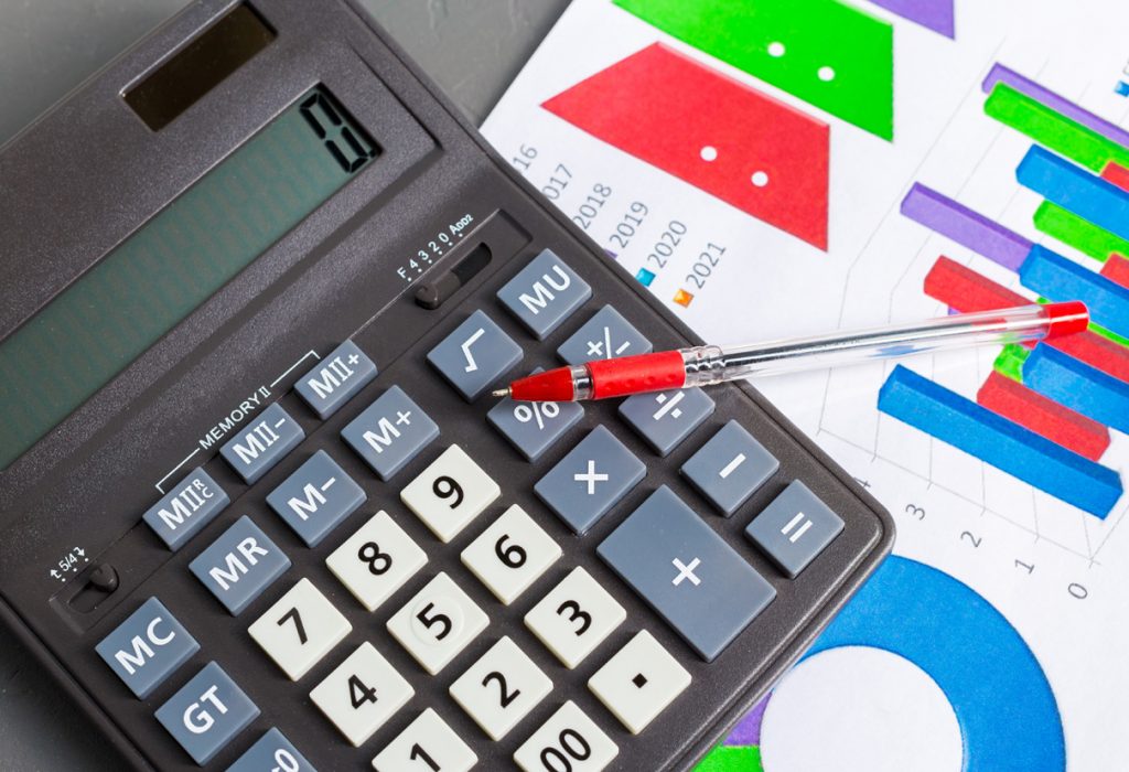 Checking accounting report on business table. Calculator Checking accounting report on business table. Calculator